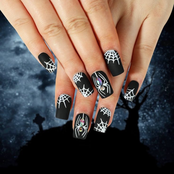 Square-matte-black-and-white-spider-nails-detailed-with-white-corner-webs-and-central-spiders-created-with-sparkling-teardrop-rhinestones.