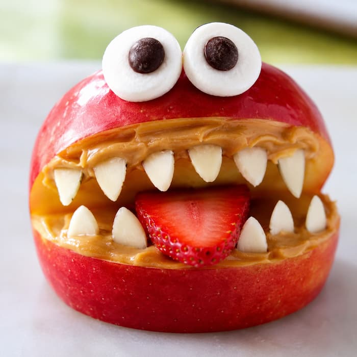 Monster-apple-mouths-made-of-red-apple-slices,-peanut-butter-and-mini-marshmallow-teeth-for-easy-halloween-snacks-for-kids