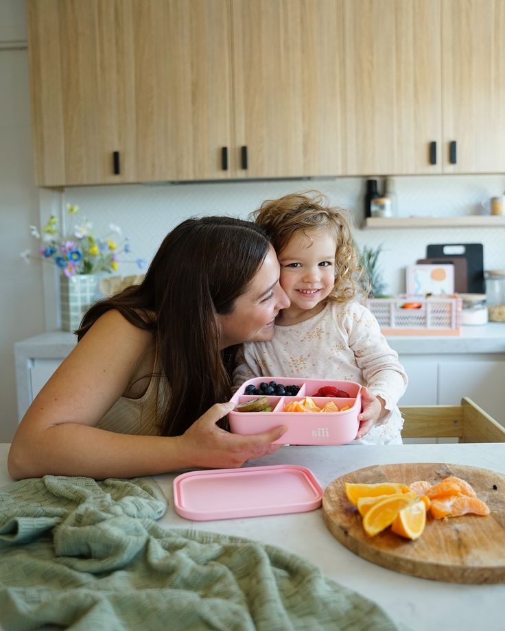 mom-packing-school-lunch-with-child-in-kitchen-morning-routine