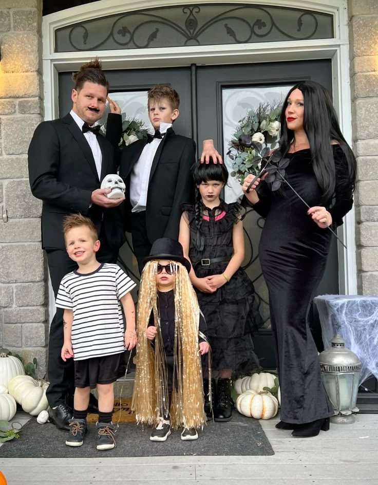 family-dressed-in-the-addams-family-costumes-as-gomez-morticia-wednesday-pugsley-lurch-and-cousin-itt