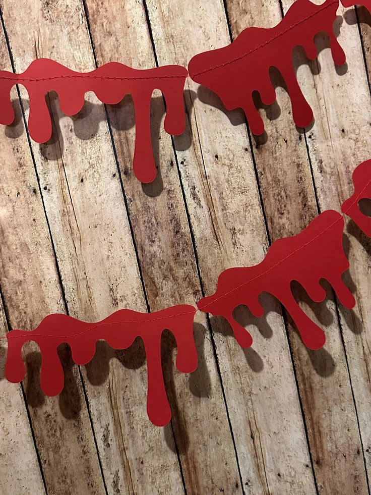 red-dripping-blood-paper-garland-against-wooden-plank-background
