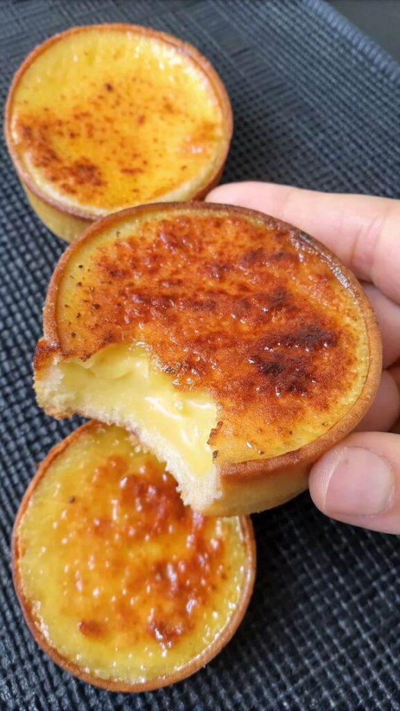 person-holding-a-miniature-creme-brulee-tart-with-a-caramelized-sugar-crust-and-creamy-custard-filling-for-thanksgiving-desserts-that-aren't-pumpkin-pie 