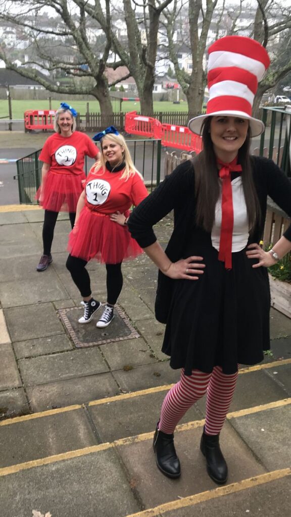 a-lady-wearing-black-skirt-black-jacket-and-red-tie-with-stripe-hat-red-and-white
