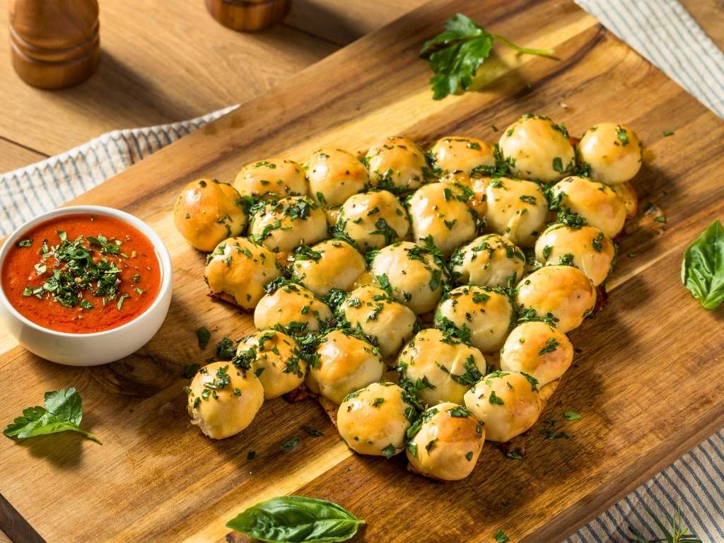 pull-apart-garlic-bread-shaped-like-a-christmas-tree-with-marinara-sauce-easy-christmas-party-potluck-ideas