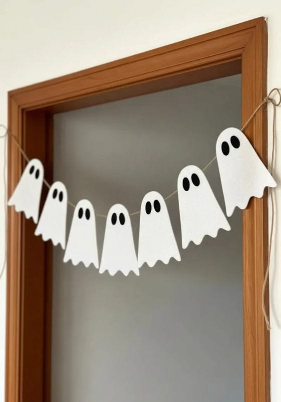 simple-white-paper-ghost-garland-hanging-across-a-wooden-doorway