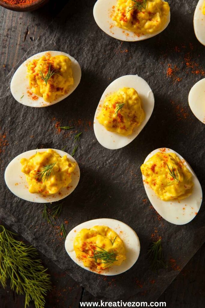 deviled-eggs-garnished-with-paprika-and-fresh-dill-on-a-slate-platter