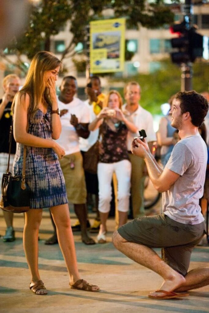 man-proposing-on-one-knee-to-surprised-woman-on-city-street-with-onlookers-for-romantic-proposal-ideas