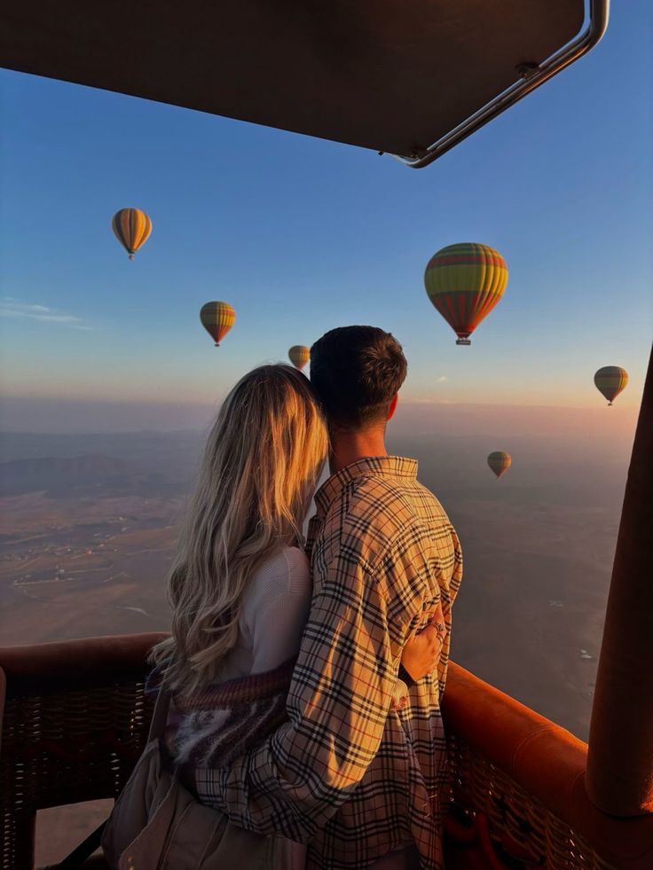 couple-embracing-inside-hot-air-balloon-basket-overlooking-scenic-landscape-at-sunrise