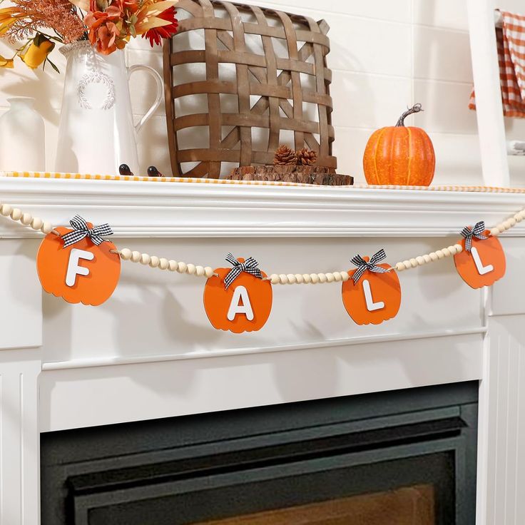 wooden-bead-garland-with-orange-pumpkins-spelling-fall-on-white-mantel