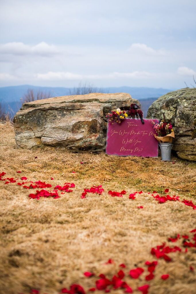 outdoor-mountaintop-proposal-spot-with-will-you-marry-me-sign-and-red-rose-petals