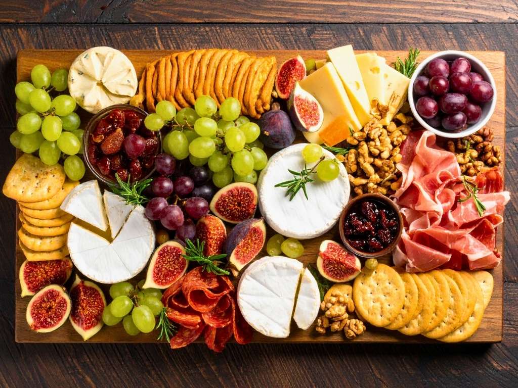 office-charcuterie-board-with-cured-meats-cheeses-figs-grapes-and-crackers