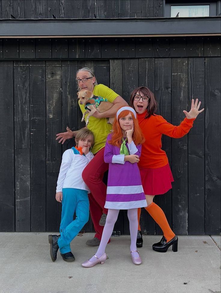 dressed-in-scooby-doo-costumes-as-shaggy-holding-a-dog-velma-daphne-and-fred