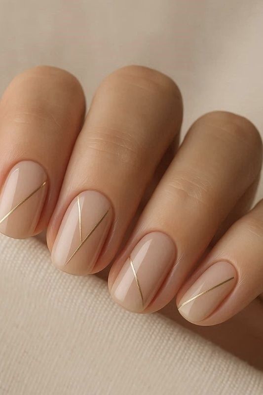 short-squoval-nude-nails-with-geometric-diagonal-gold-line-art