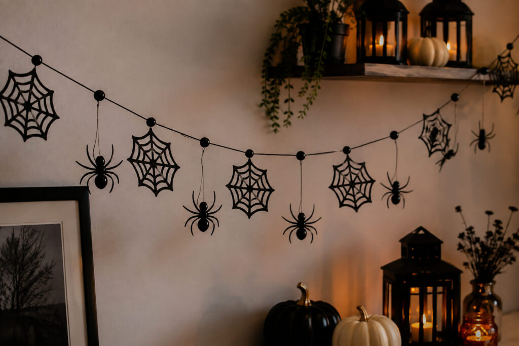 black-spider-and-cobweb-garland-draped-over-mantel-with-lit-candles