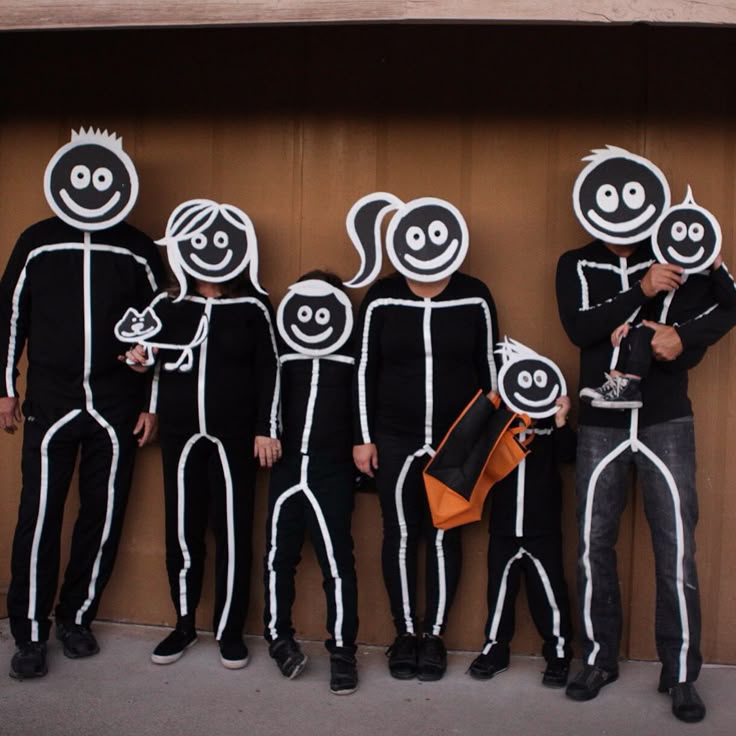 family-dressed-in-black-and-white-glowing-stick-figure-costumes-with-cartoon-face-cutouts