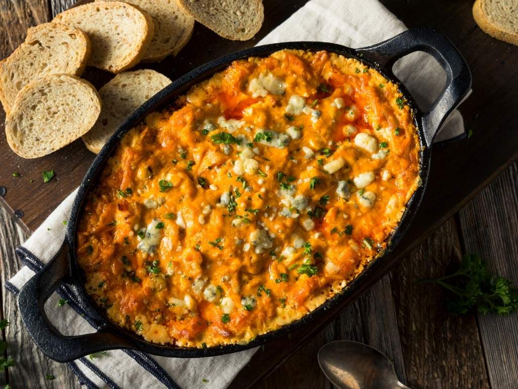 baked-buffalo-chicken-dip-in-a-cast-iron-skillet-with-sliced-bread-easy-christmas-party-potluck-ideas