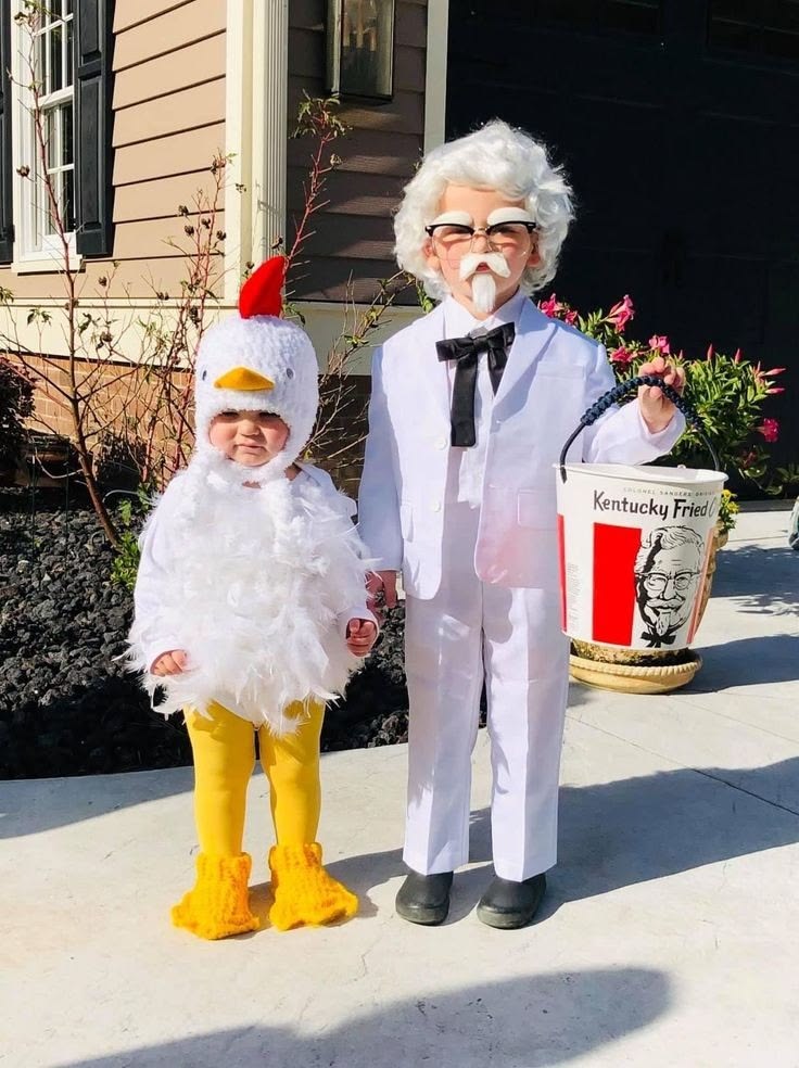two-toddlers-wearing-a-colonel-sanders-white-suit-costume-and-a-plush-white-chicken-costume-with-a-kfc-bucket-for-halloween-costume-ideas-for-kids