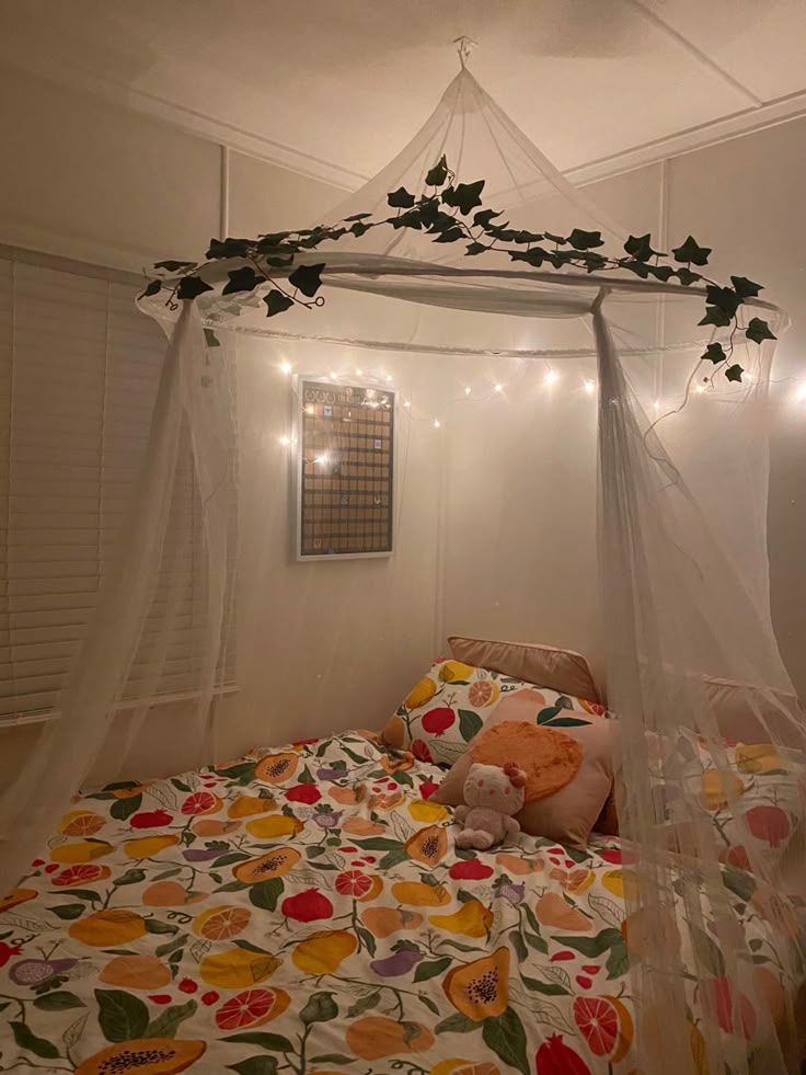 a-sheer-diy-bed-canopy-draped-from-the-ceiling-with-faux-ivy-garlands-over-a-fruit-patterned-bedspread