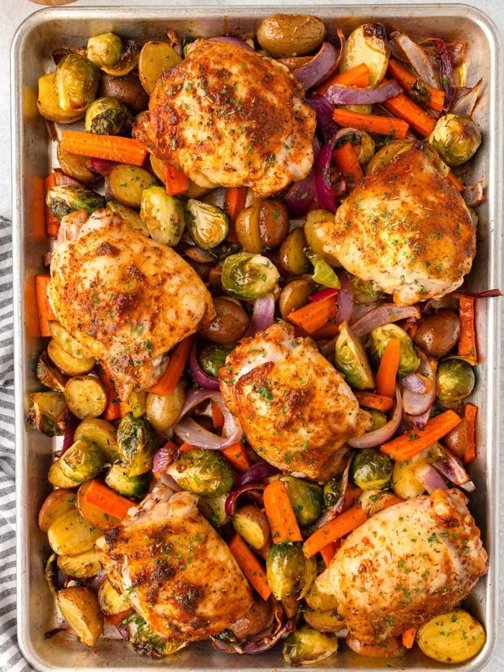 roasted-chicken-thighs-with-baby-potatoes-brussels-sprouts-carrots-and-red-onion-on-a-baking-tray