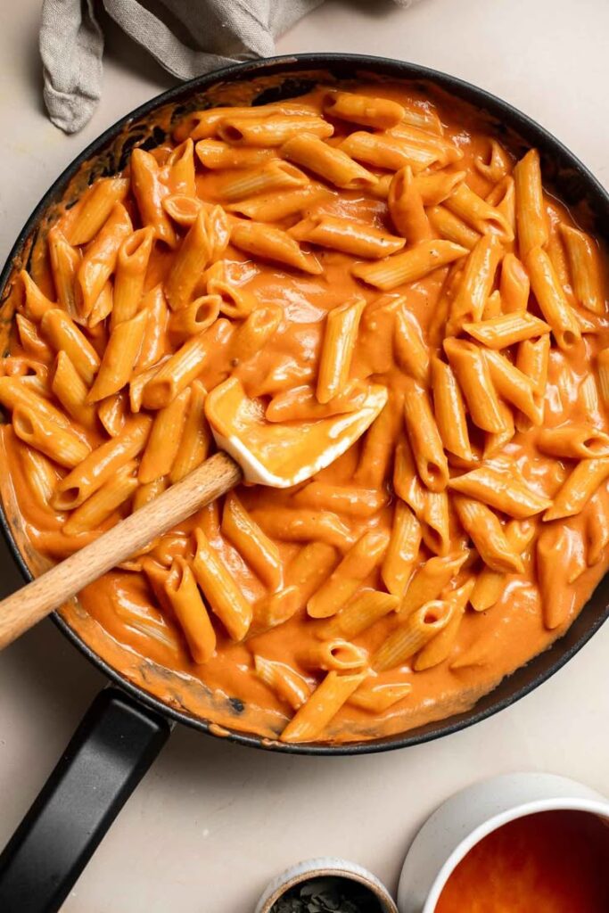 creamy-tomato-penne-pasta-in-a-black-skillet-with-a-wooden-spatula