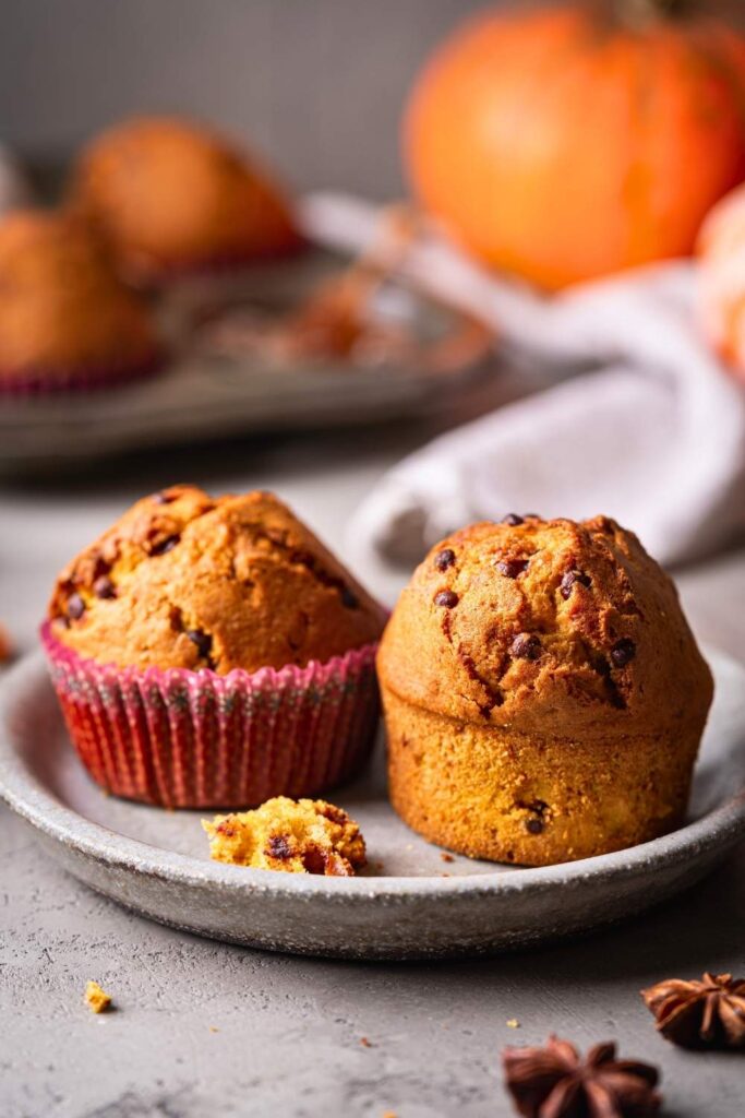 pumpkin-chocolate-chip-muffins-on-a-plate-with-a-fresh-pumpkin-and-star-anise-in-the-background-for-fall-breakfast-ideas