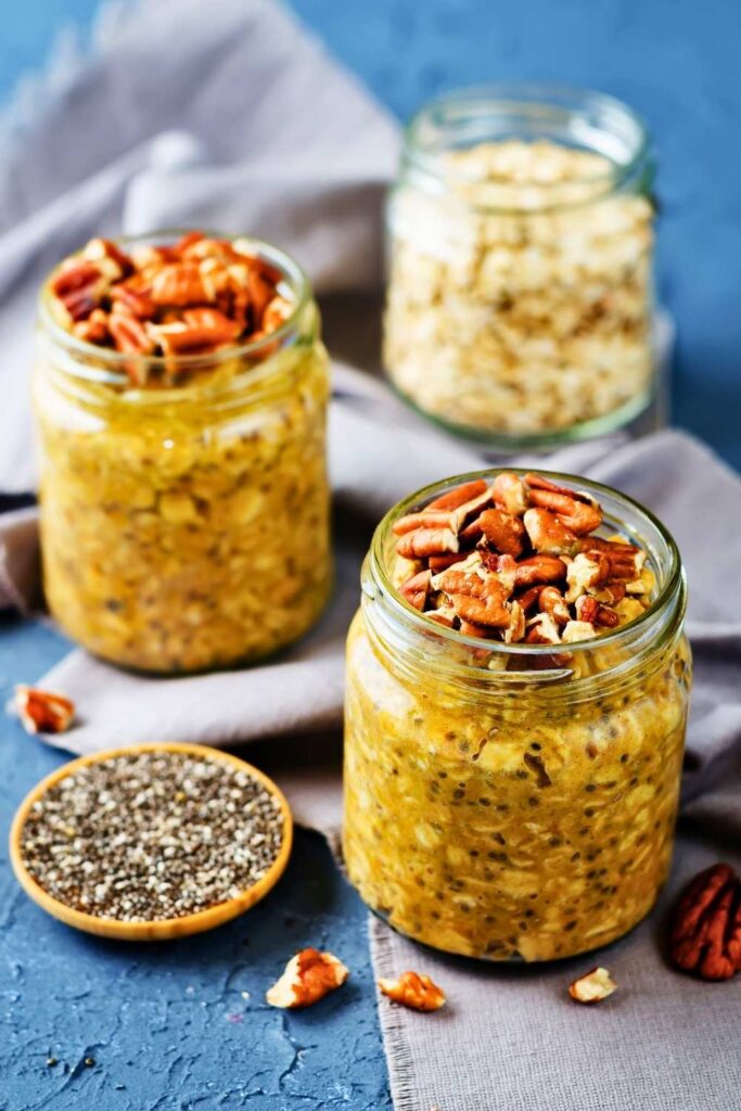 pumpkin-overnight-oats-with-chia-seeds-in-glass-jars-topped-with-chopped-pecans
