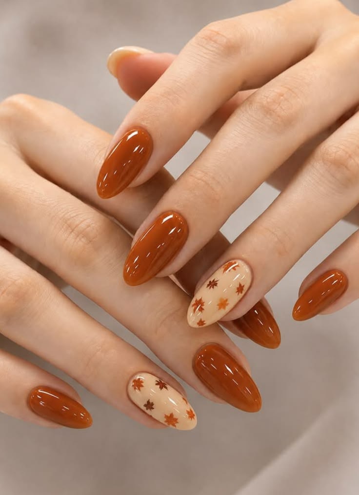 glossy-burnt-orange-almond-nails-with-tiny-autumn-leaves-accent-nail