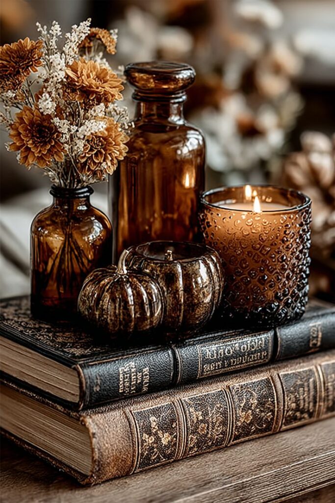 vintage-nightstand-decor-with-stacked-leather-bound-books-amber-glass-bottles-dried-flowers-and-textured-candle-holder 8. Give Your Bathroom a Cozy Refresh-fall-decorating-ideas-for-small-spaces