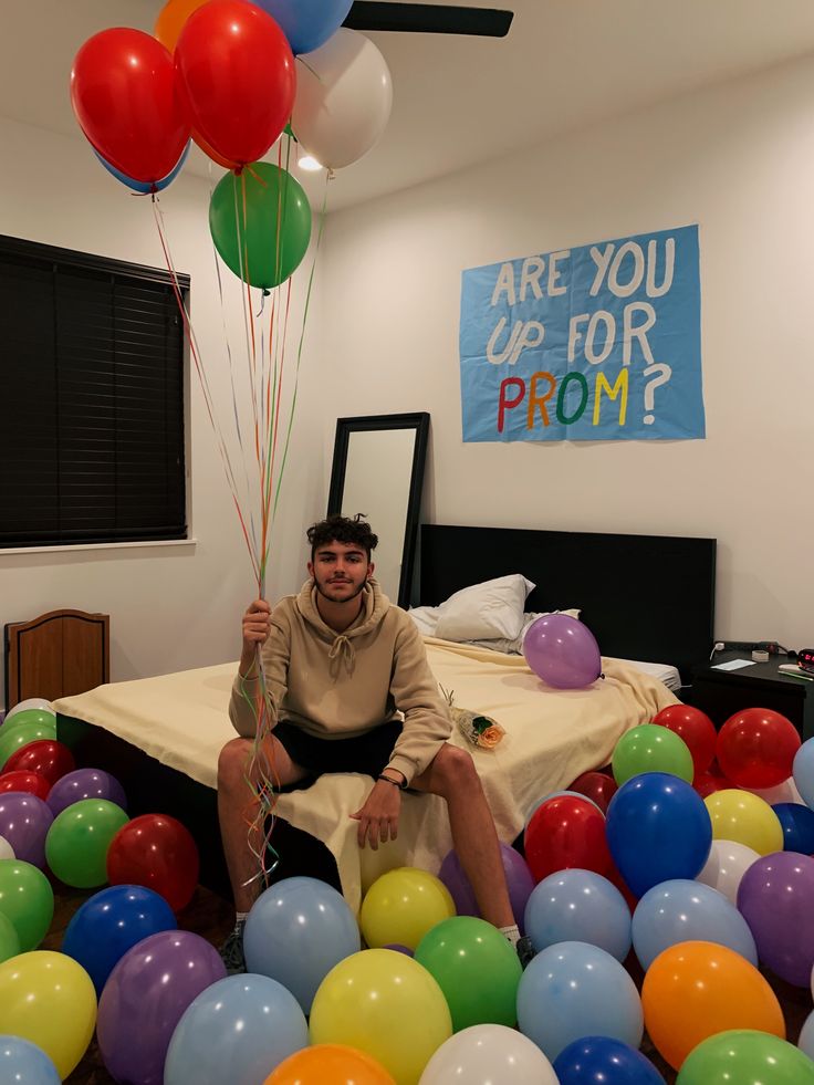 teen-sitting-in-balloon-filled-room-with-are-you-up-for-prom-banner
