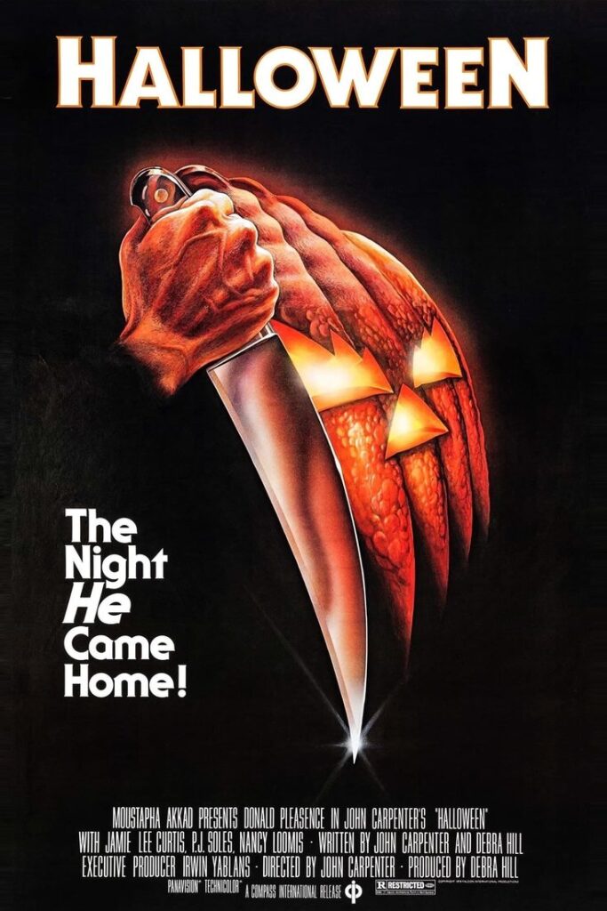halloween-1978-movie-poster-featuring-a-hand-holding-a-kitchen-knife-beside-a-carved-jack-o-lantern-Halloween-movies-to-watch