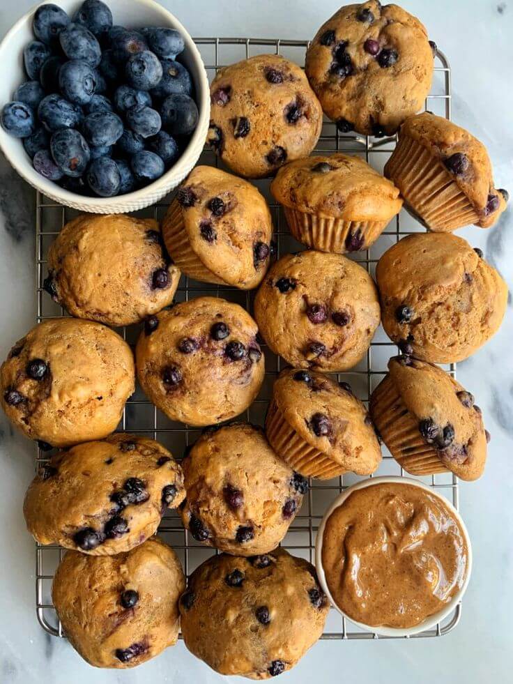 freshly-baked-blueberry-muffins-cooling-on-a-wire-rack-with-a-bowl-of-fresh-blueberries-and-nut-butter