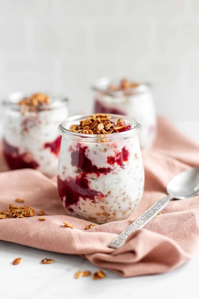 overnight-oats-parfait-in-a-glass-jar-layered-with-berry-compote-and-topped-with-crunchy-granola-thanksgiving-breakfast-ideas