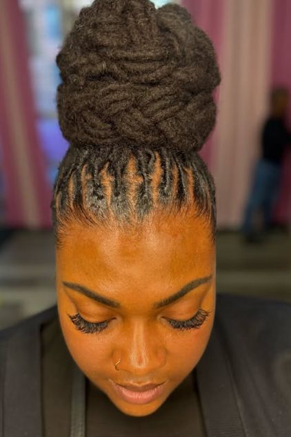 close-up-front-view-of-a-woman-with-dark-locs-styled-in-an-elegant-woven-high-updo-bun