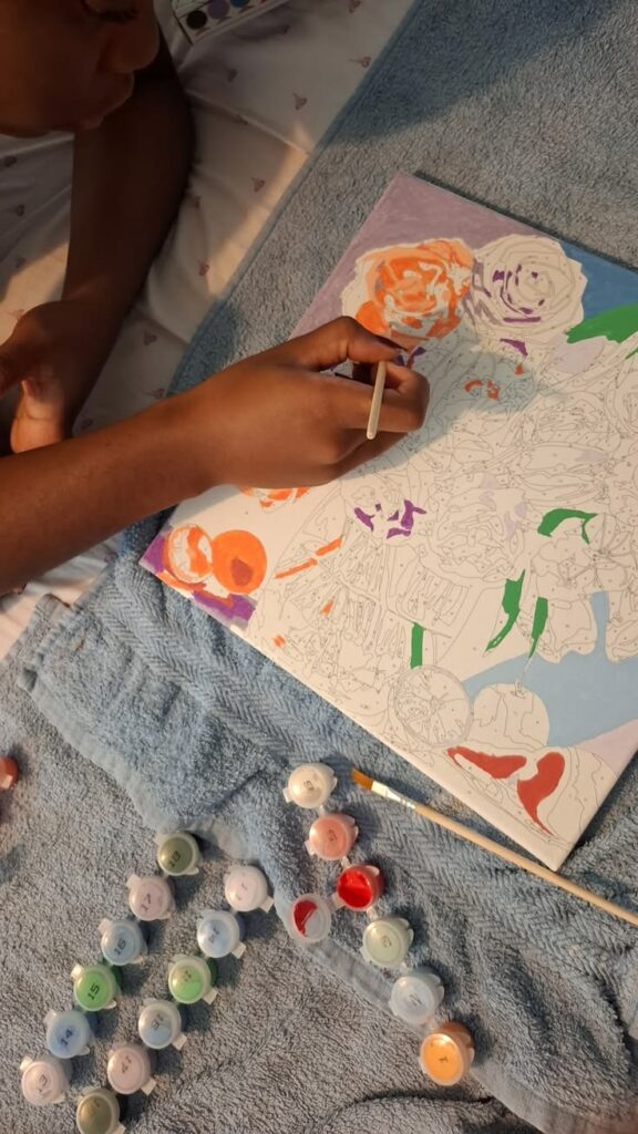 person-painting-a-colorful-floral-canvas-with-acrylic-paint-pots